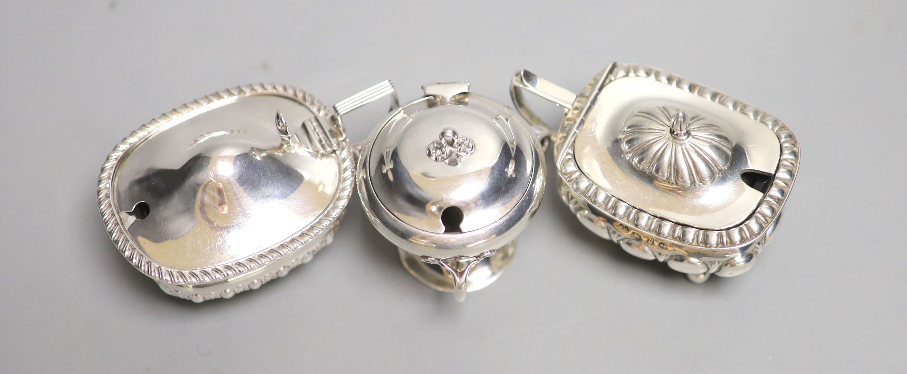 Three assorted 20th century silver mustard pots including Art Nouveau, Birmingham, 1909, tallest 6cm.